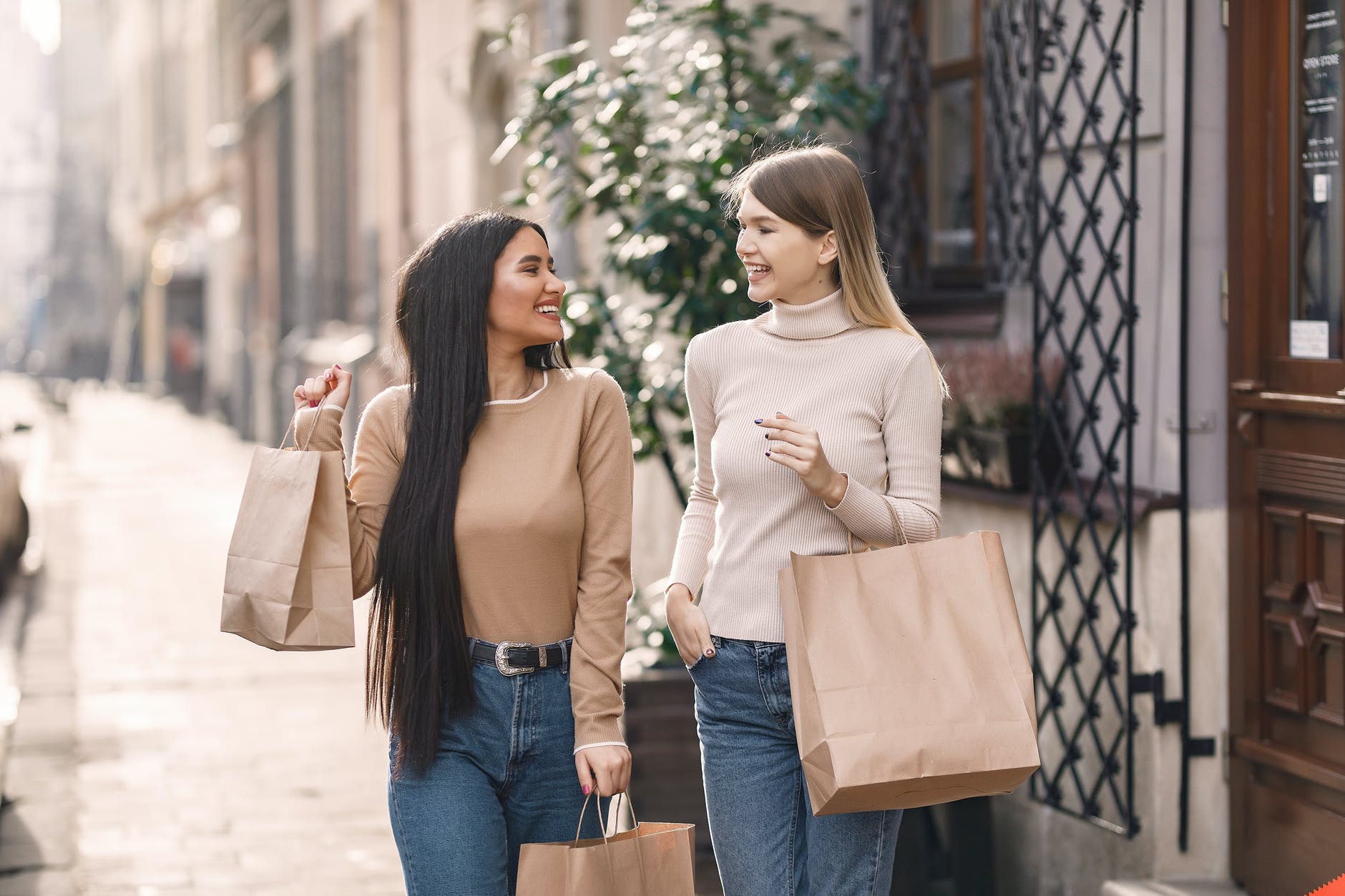 cheerful friends carrying shopping bags and smiling