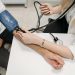 a healthcare worker measuring a patient s blood pressure using a sphygmomanometer